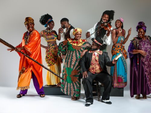 Group of people dressed in brightly colored costumes posing for the camera
