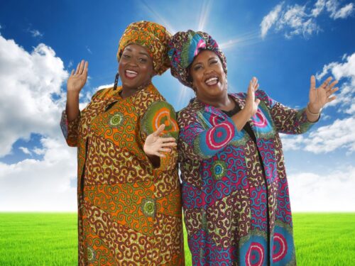 two women, cheek to cheek in brightly colored African looking costumes