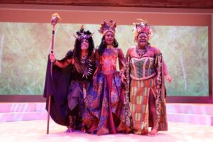 Actors dressed in colorful costumes as gods in Once on this Island.